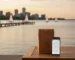 Burlington weed delivery package on lakefront porch with Spencer Smith Park waterfront at sunset, smartphone tracking map