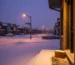 Milton cannabis delivery package on snowy doorstep during winter evening with warm home lighting and suburban street scene
